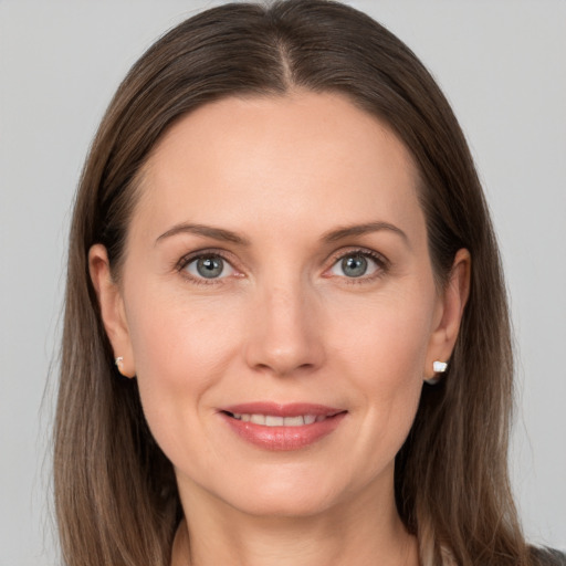 Joyful white young-adult female with long  brown hair and grey eyes