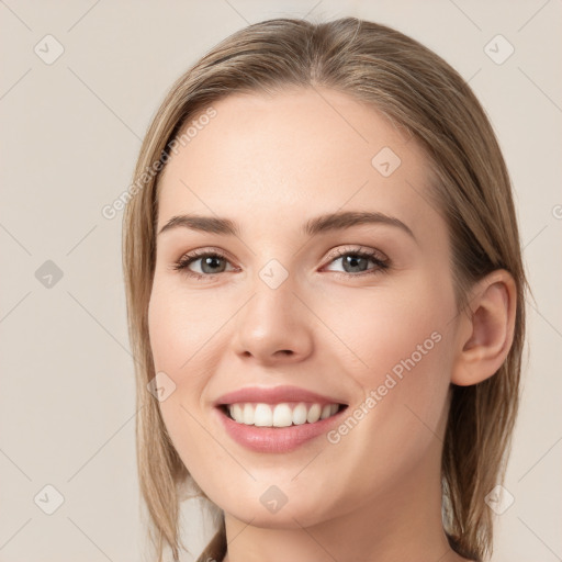 Joyful white young-adult female with long  brown hair and grey eyes