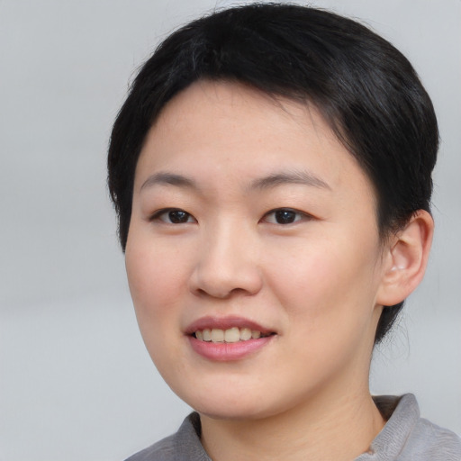 Joyful asian young-adult female with short  black hair and brown eyes