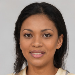 Joyful black young-adult female with long  brown hair and brown eyes