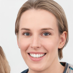 Joyful white young-adult female with long  brown hair and blue eyes