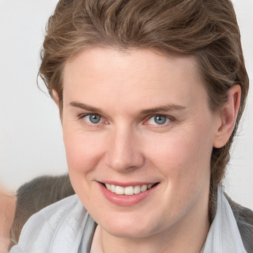 Joyful white young-adult female with medium  brown hair and blue eyes