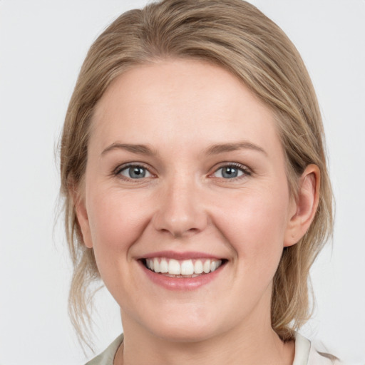 Joyful white young-adult female with medium  brown hair and grey eyes