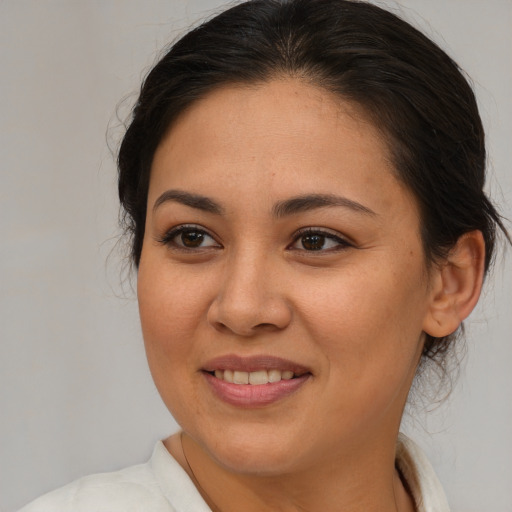 Joyful latino young-adult female with medium  brown hair and brown eyes