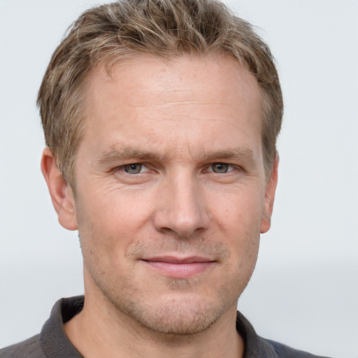 Joyful white adult male with short  brown hair and grey eyes