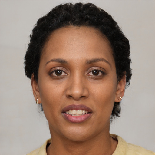 Joyful black young-adult female with short  brown hair and brown eyes