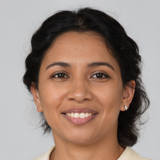 Joyful latino young-adult female with medium  brown hair and brown eyes