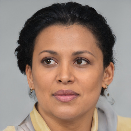 Joyful latino adult female with medium  brown hair and brown eyes
