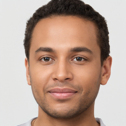 Joyful latino young-adult male with short  brown hair and brown eyes