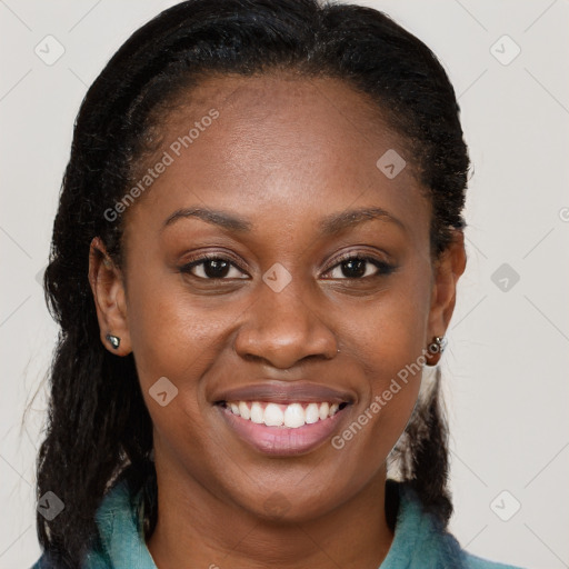 Joyful black young-adult female with long  brown hair and brown eyes