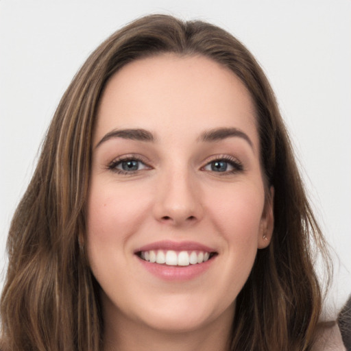 Joyful white young-adult female with long  brown hair and grey eyes