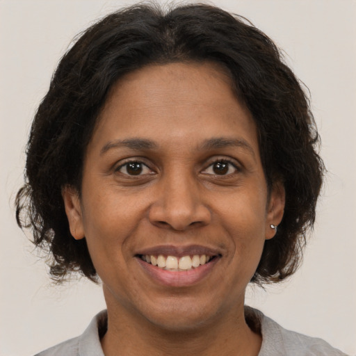 Joyful black adult female with medium  brown hair and brown eyes
