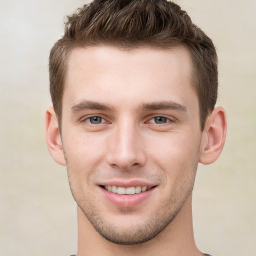 Joyful white young-adult male with short  brown hair and grey eyes