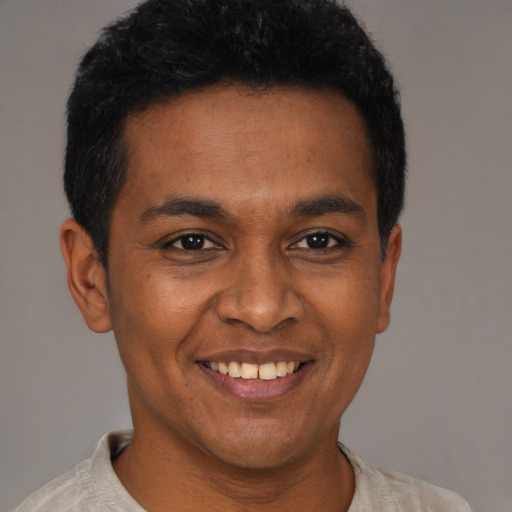 Joyful latino young-adult male with short  black hair and brown eyes