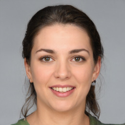 Joyful white young-adult female with medium  brown hair and green eyes