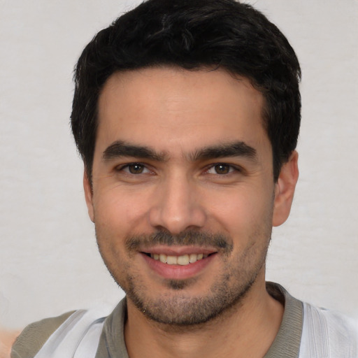 Joyful white young-adult male with short  black hair and brown eyes