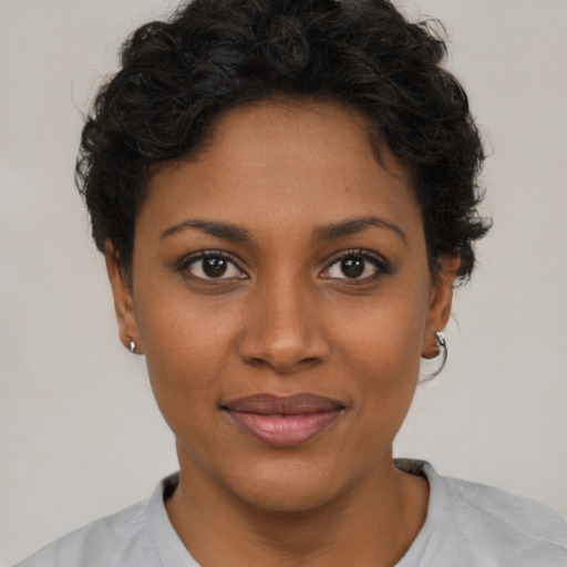 Joyful black young-adult female with short  brown hair and brown eyes