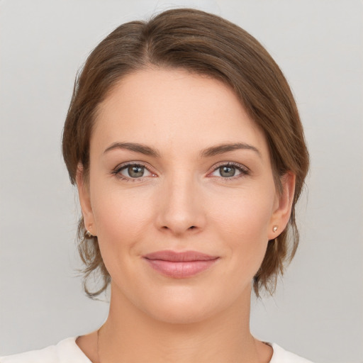 Joyful white young-adult female with medium  brown hair and grey eyes