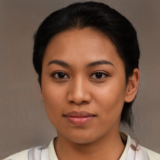 Joyful latino young-adult female with short  black hair and brown eyes