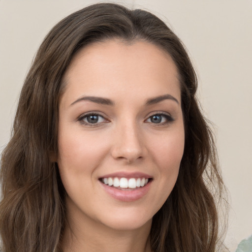 Joyful white young-adult female with long  brown hair and green eyes