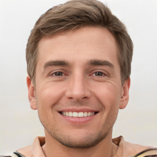 Joyful white young-adult male with short  brown hair and grey eyes