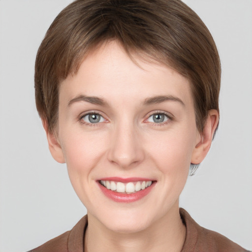 Joyful white young-adult female with short  brown hair and grey eyes