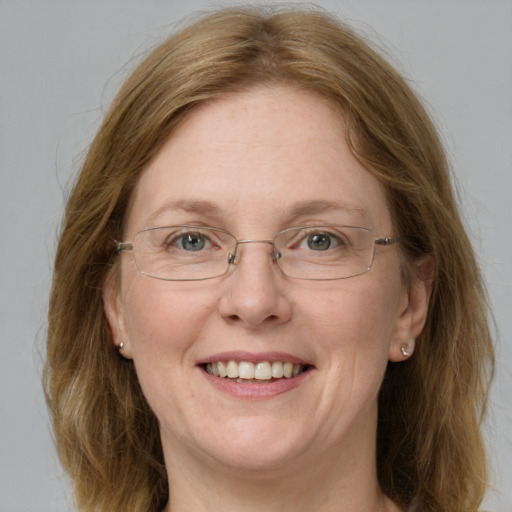 Joyful white adult female with medium  brown hair and blue eyes