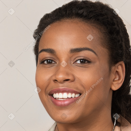 Joyful black young-adult female with long  brown hair and brown eyes