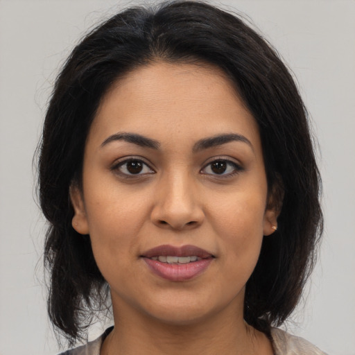 Joyful latino young-adult female with medium  brown hair and brown eyes