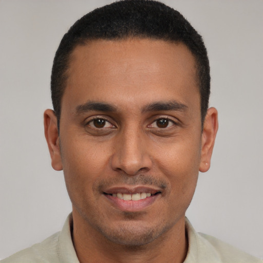 Joyful latino young-adult male with short  brown hair and brown eyes