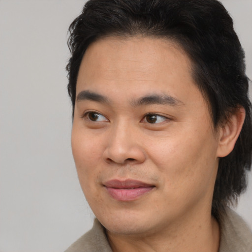 Joyful asian young-adult male with short  brown hair and brown eyes