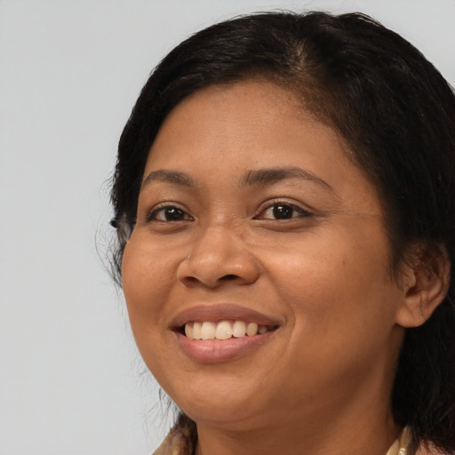 Joyful latino adult female with medium  brown hair and brown eyes