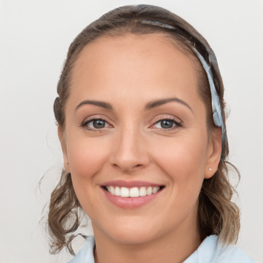 Joyful white young-adult female with medium  brown hair and blue eyes