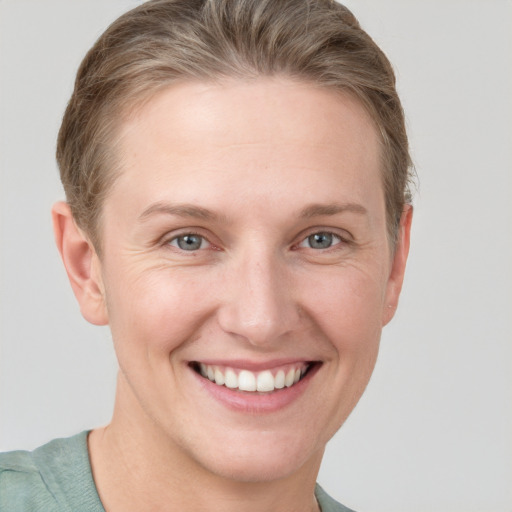 Joyful white young-adult female with short  brown hair and blue eyes