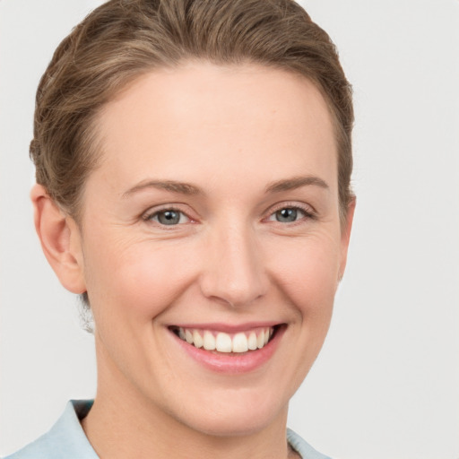 Joyful white young-adult female with short  brown hair and grey eyes