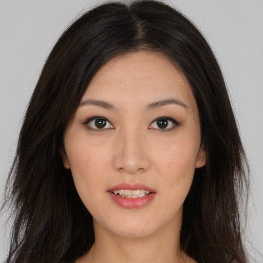 Joyful asian young-adult female with long  brown hair and brown eyes