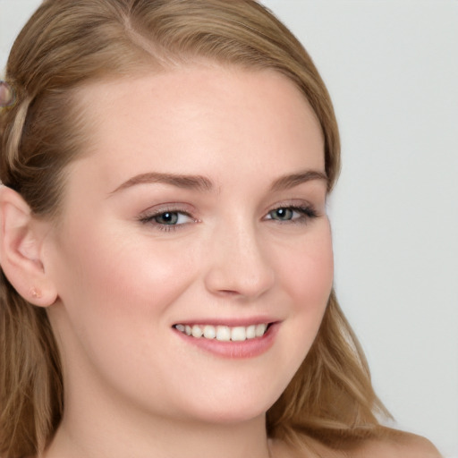 Joyful white young-adult female with long  brown hair and blue eyes