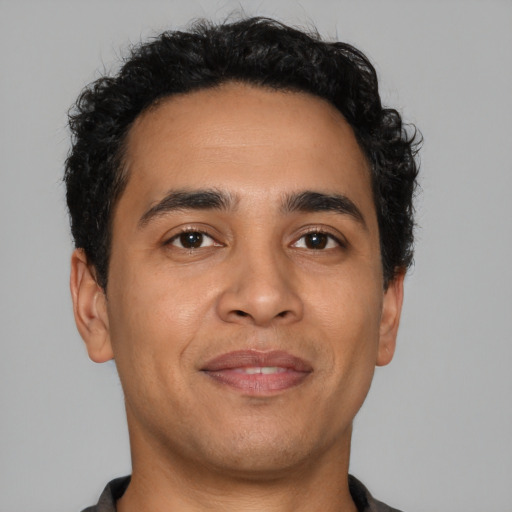 Joyful latino young-adult male with short  brown hair and brown eyes