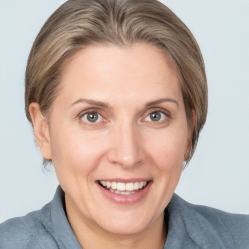 Joyful white adult female with medium  brown hair and grey eyes