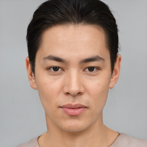 Joyful asian young-adult male with short  brown hair and brown eyes