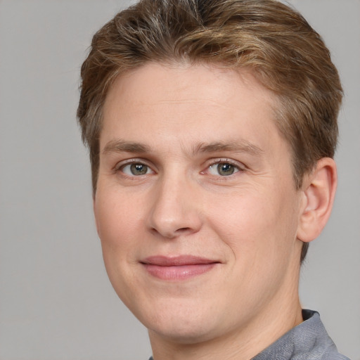 Joyful white adult male with short  brown hair and grey eyes