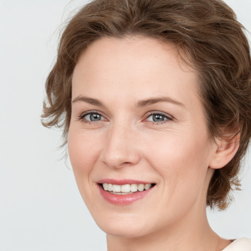 Joyful white young-adult female with medium  brown hair and green eyes