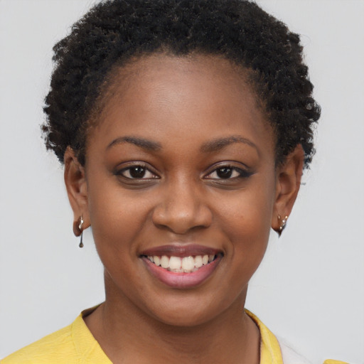 Joyful black young-adult female with short  brown hair and brown eyes