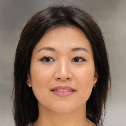 Joyful asian young-adult female with medium  brown hair and brown eyes