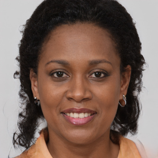 Joyful black adult female with medium  brown hair and brown eyes
