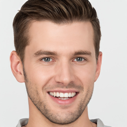 Joyful white young-adult male with short  brown hair and grey eyes