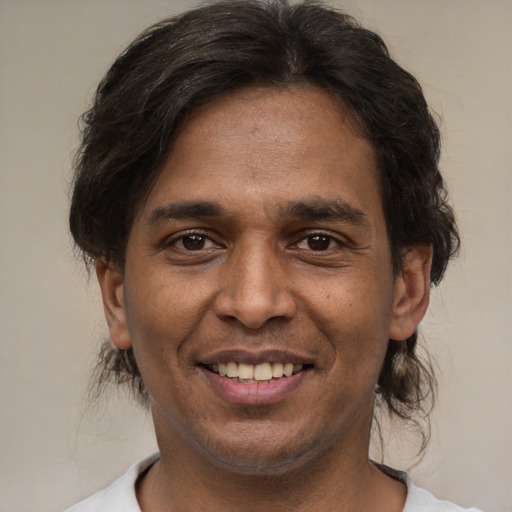 Joyful latino adult male with short  brown hair and brown eyes