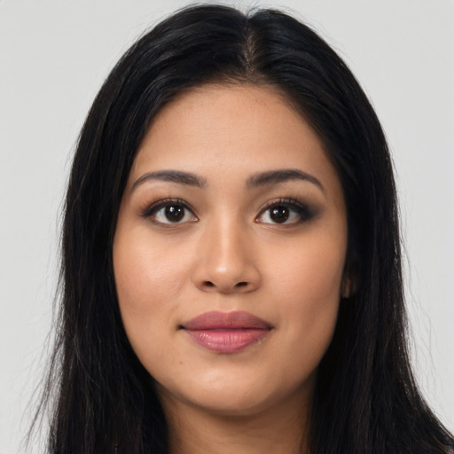 Joyful latino young-adult female with long  black hair and brown eyes
