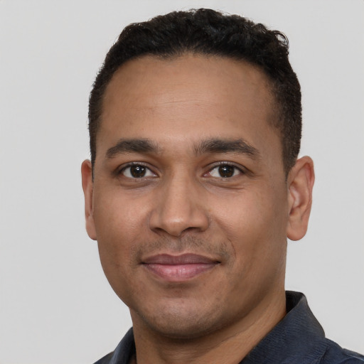 Joyful latino young-adult male with short  black hair and brown eyes
