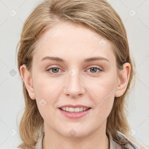 Joyful white young-adult female with long  brown hair and blue eyes